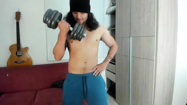 Loganviking muscular brunette lifting weights shirtless in sweatpants
