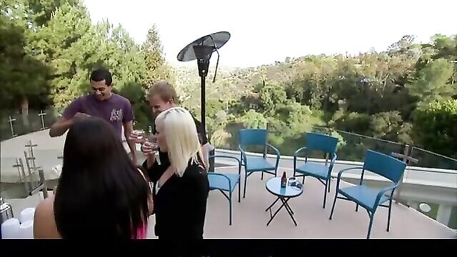 Hot foursome on balcony: tan guy, blonde, Asian, brunette toasting drinks