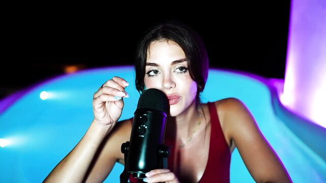 Emily Black ASMR girlfriend in red dress holds mic by hot tub pool
