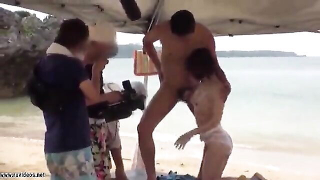 JAV behind-scenes outdoor sex: nude man lifts Asian girl fucking on beach