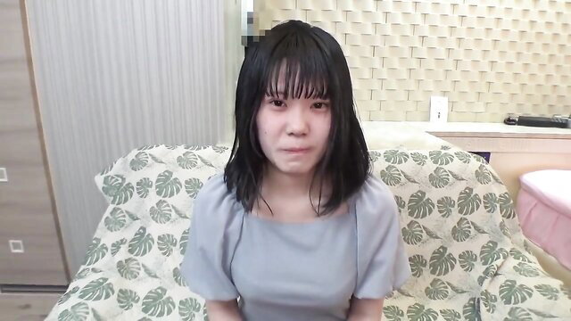 Cute Asian JAV girl with bangs, wet black hair, pouting on sofa