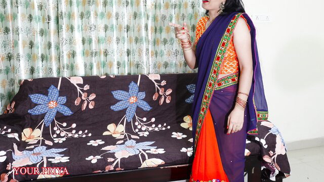 Curvy Indian woman in orange saree and bangles holds drink seductively