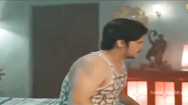 Asian man in tank top sits on bed in Ullu Sona Part 02 scene