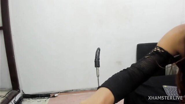 Sultry Asian girl in fishnet sleeves teases with huge black dildo on cam