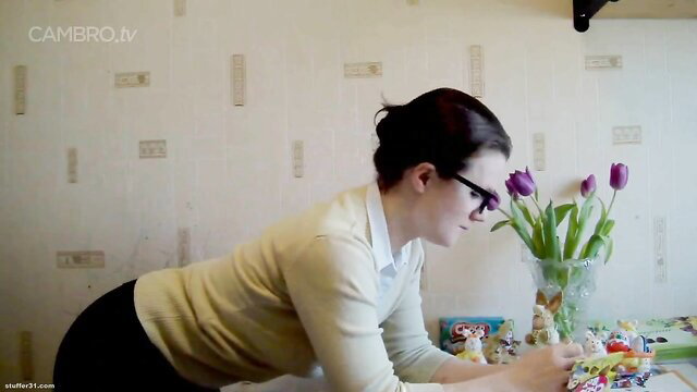Alissa in tight pants bends over Easter table with tulips