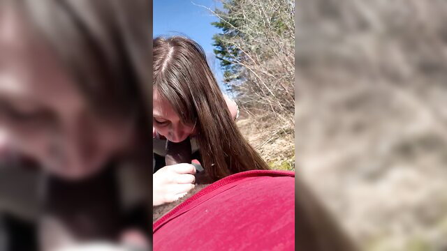White girl with long brown hair kneels outdoors by red stroller, teasing smile