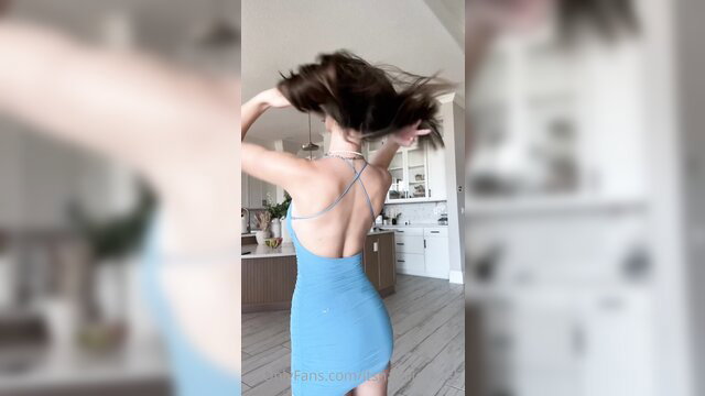 Brunette in tight blue backless dress twirls in kitchen, sexy tease
