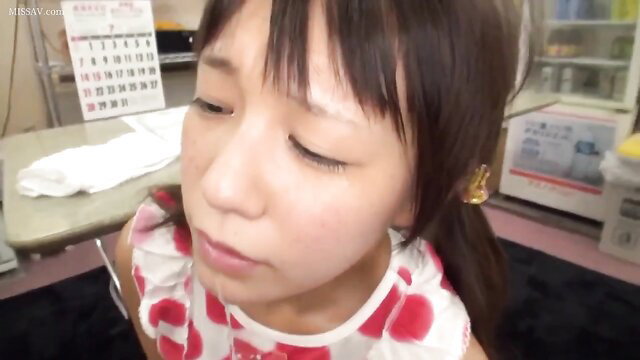 Closeup of cute Japanese girl's face with sleepy eyes and polka dot dress