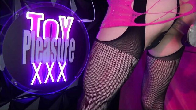 Sissy in pink fishnet lingerie and stockings poses sexy by Toy Pleasure XXX neon sign