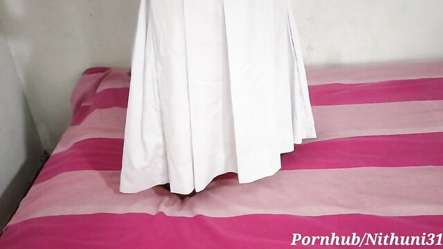Sri Lankan schoolgirl in white uniform skirt over pink bed, teasing 18+ blowjob fuck