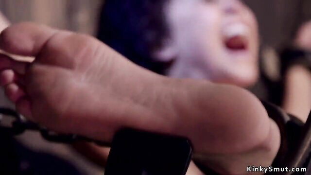 Gagged black woman bound, feet exposed in BDSM flogging scene