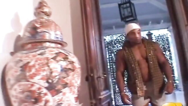 Muscular Brazilian hunk in open vest and cap at doorway