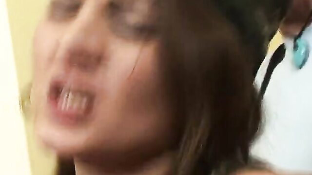 Closeup of busty brunette's open mouth and big tits in steamy adult video