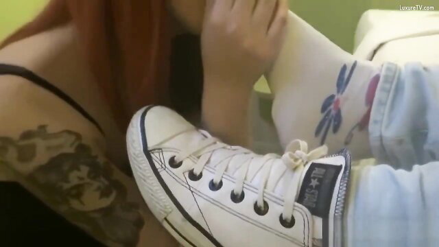 Redhead tattooed woman in Converse sneakers and socks teases foot slave