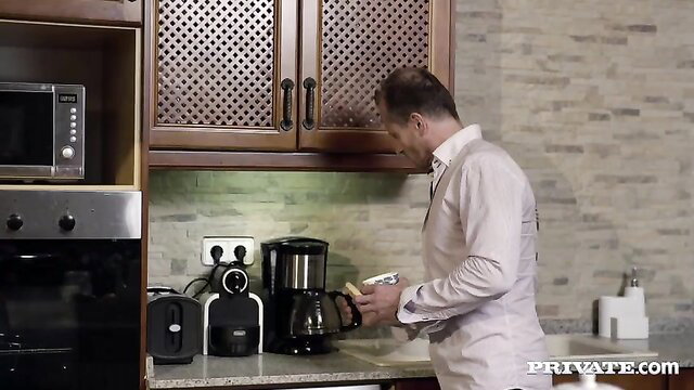 Mature man making coffee in kitchen before group sex with blonde