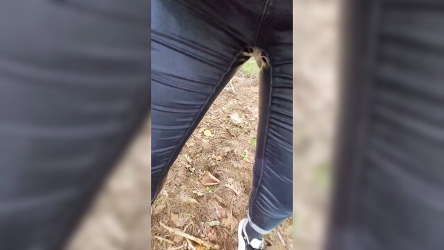 Cute girl desperate pee wetting tight jeans in forest outdoors