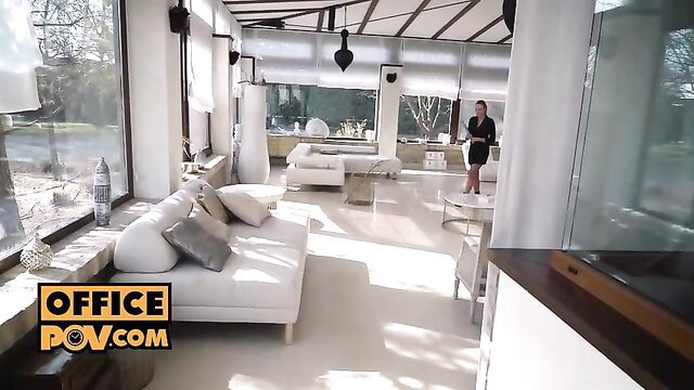 Blonde in tight dress stands in modern office POV view