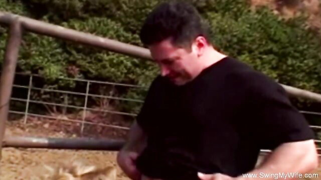 Muscular Latino man in black tee grabs crotch outdoors at Swing Wife ranch