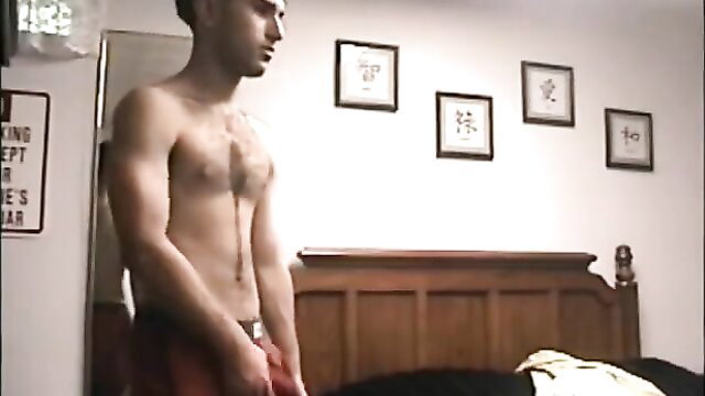 Skinny white guy with chest hair masturbates vigorously in red shorts motel room