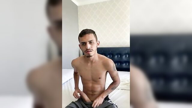 Hot Latino twink with tattoos sits shirtless pulling down sweats, big cummer tease