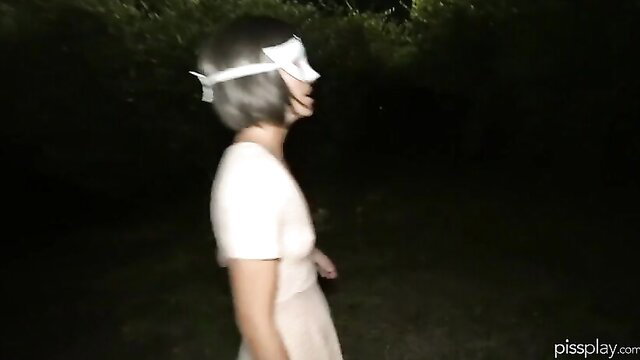 Woman in white mask and dress at night in public Bruce Morgan PissPlay scene
