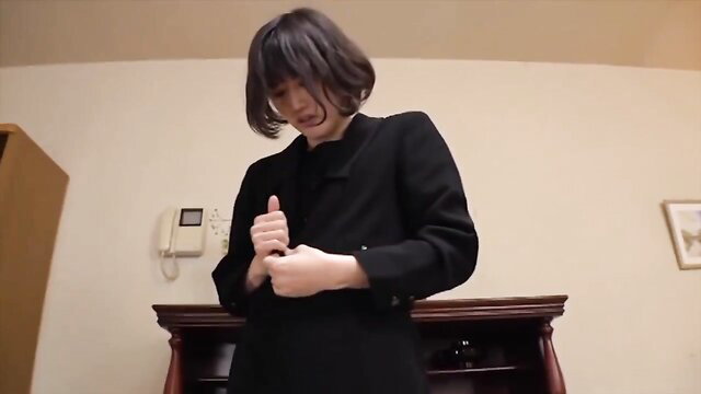 Asian woman in black suit jacket, hands teasing buttons, seductive office tease