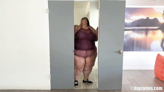 SSBBW in sheer purple lingerie peeking from bathroom door on house tour
