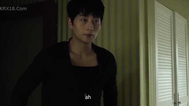 Handsome Korean man in black top smirks in tense bedroom scene