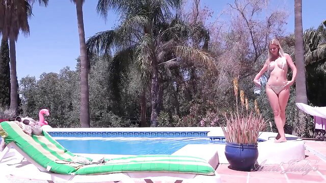 Blonde MILF covering her perky tits with hands while teasing in tiny thong by the pool