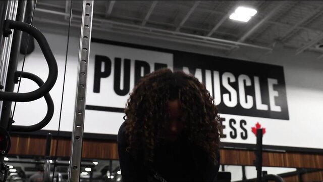 Curly haired black woman in gym on cheat day glutes workout