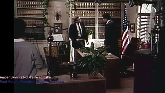 Amber Lynn in office with suited men, professional porn scene