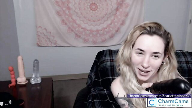 ScarletteMoonXO blonde cam girl smiles with dildos on table
