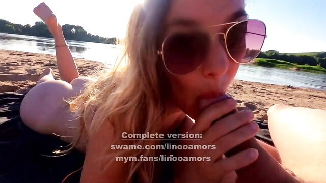 Blonde babe in sunglasses sucking on beach by river, hot public tease