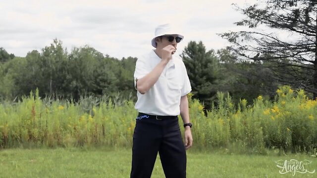 Emma Rose in white shirt, black pants, white bucket hat outdoors