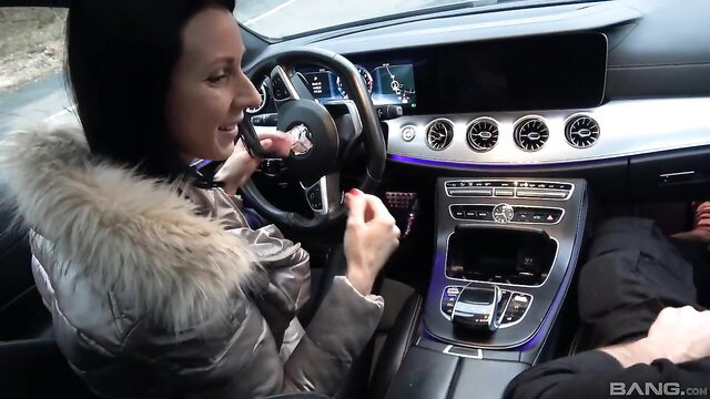 Brunette in fur coat talks on phone in luxury Mercedes car