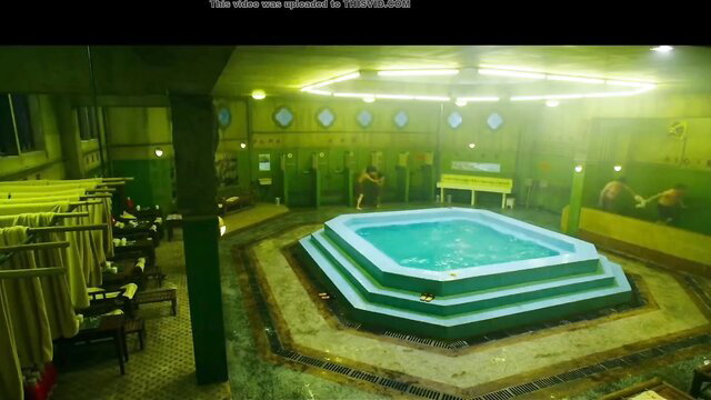 Men grabbing balls in green-lit bathhouse hot tub M/M action