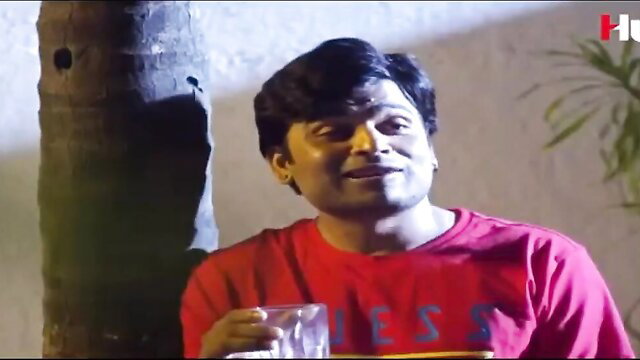 Indian man in red Guess shirt holding drink, smiling seductively