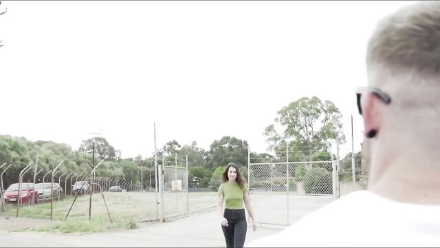 Kiki approaches locked gate in chastity prison, teasing from behind bars