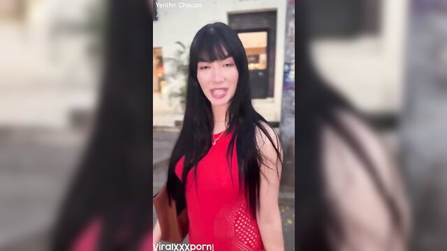 Jenifer Chacon in sexy red dress smirking outdoors