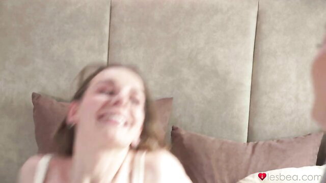 Kinky lesbian MILF smiling in bed, bringing dildo to work