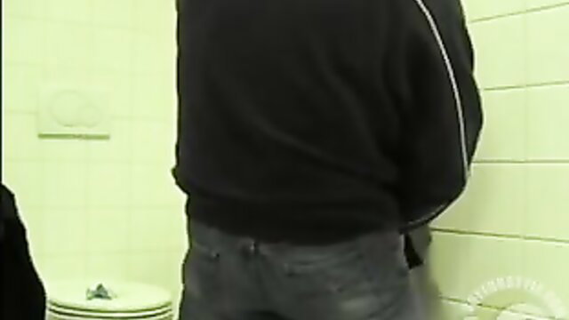 Man in black sweater stands in public restroom for quick anal doggystyle