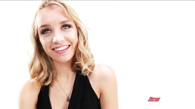 Aurora Belle smiling blonde in black halter dress, fetish blowbang star