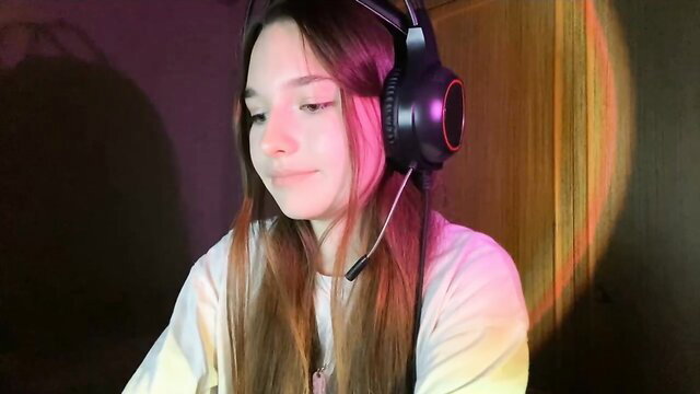 Vergiezaic cute 18yo teen camgirl in headset, smiling softly
