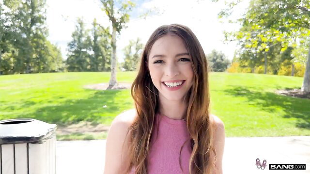 Myra Moans smiling outdoor in pink top, long hair