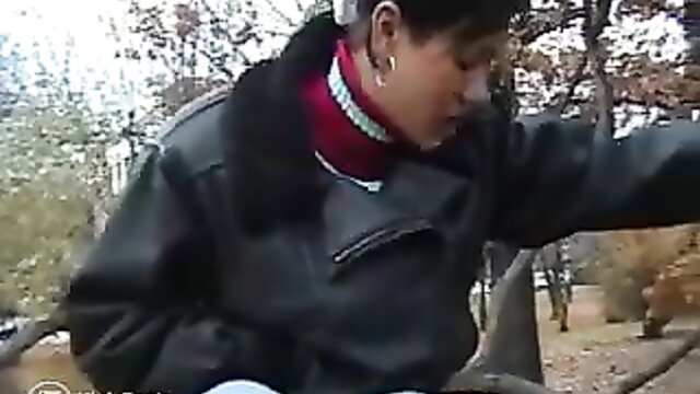 Asian woman in fur coat by park bench, public pants mess tease