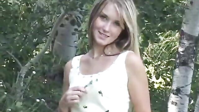 Petite babe Jewel strips naked outdoors in woods, smiling tease