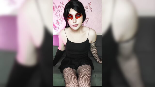 Gothic crossdresser in black lingerie, fishnets, red makeup seductive pose
