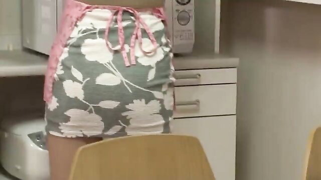 Hot mom in floral apron skirt bending over kitchen counter