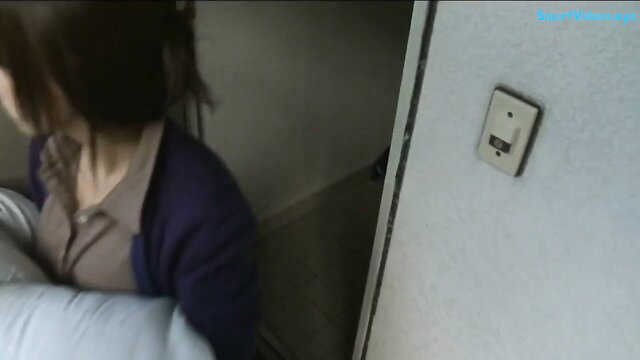 Mature Japanese woman in purple cardigan by bed, light switch view