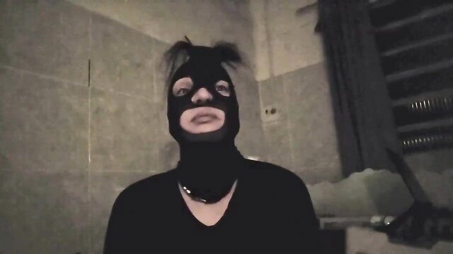 Mystery woman in black balaclava mask with ponytails in dark bathroom tease